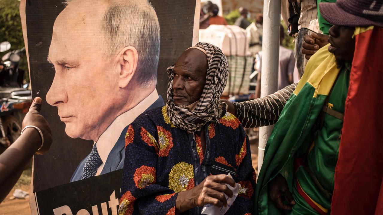 Ein mann sit framfor portrettet til russisk president Vladimir Putin under ein demonstrasjon i Mali.
