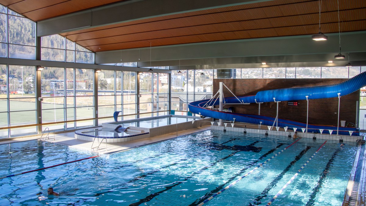 Interiør frå ein svømmehall med to basseng og ei sklie FOTO: Henrik Storm Henriksen/NRK