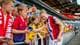 Beate Oma Dahle / NTB En fotballspiller signerer autografer til supportere på tribunen. De holder opp mobiltelefoner for å ta bilde. Spilleren er iført en rød, hvit og blå drakt. Supporterne er barn og ungdommer. (Bildebeskrivelsen er laget av en KI-tjeneste)