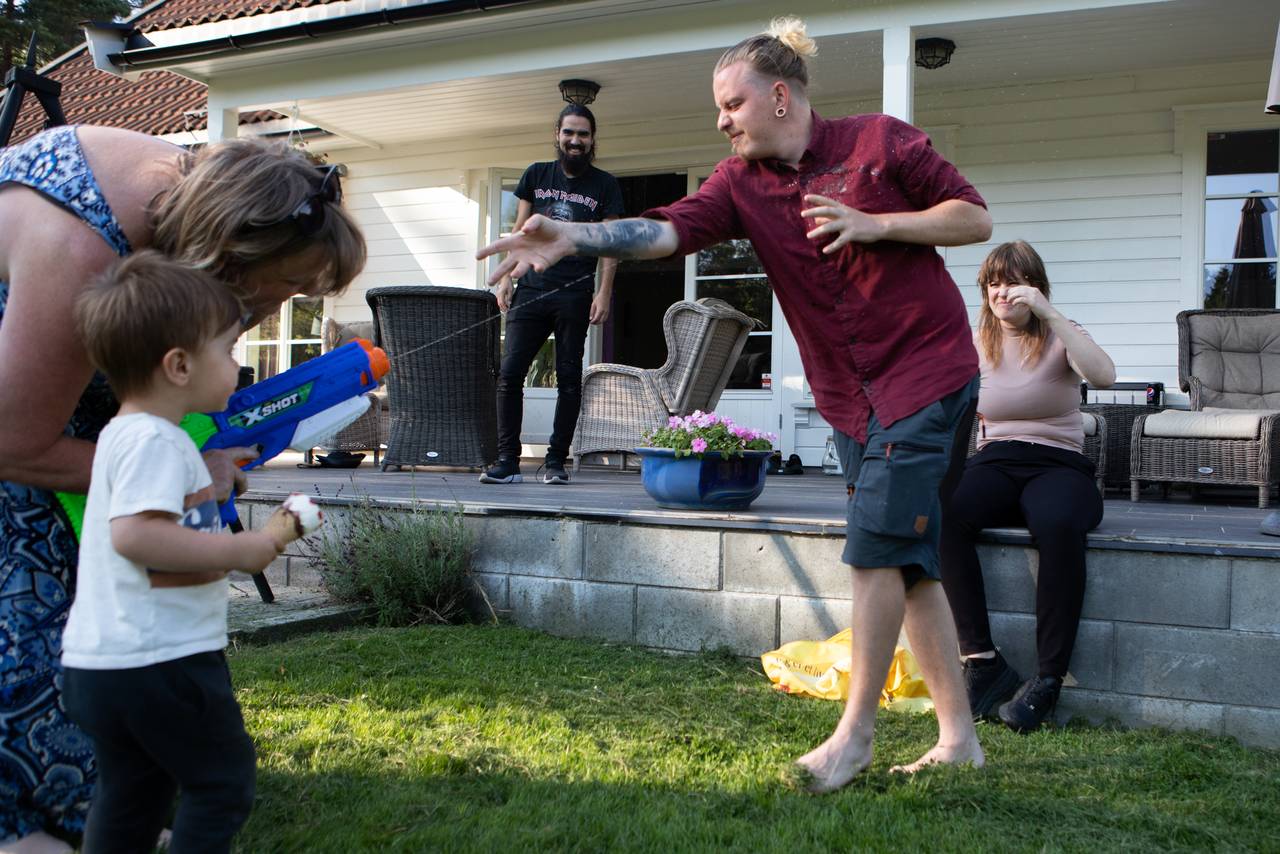 Anne-Grete og barnebarnet skyter med vannpistol på sønnen, Ole Andreas.