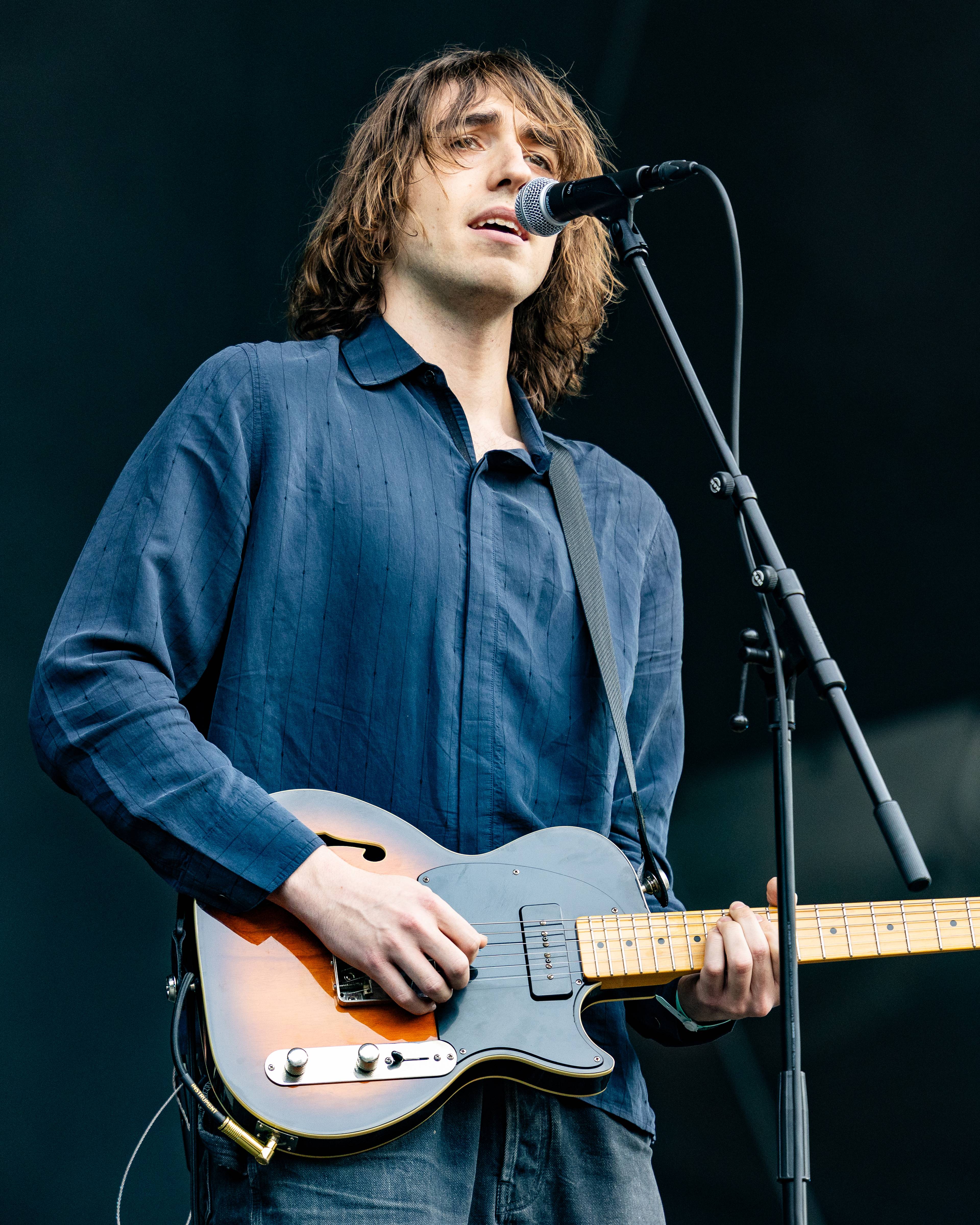 Artist synger og spiller gitar på scenen.