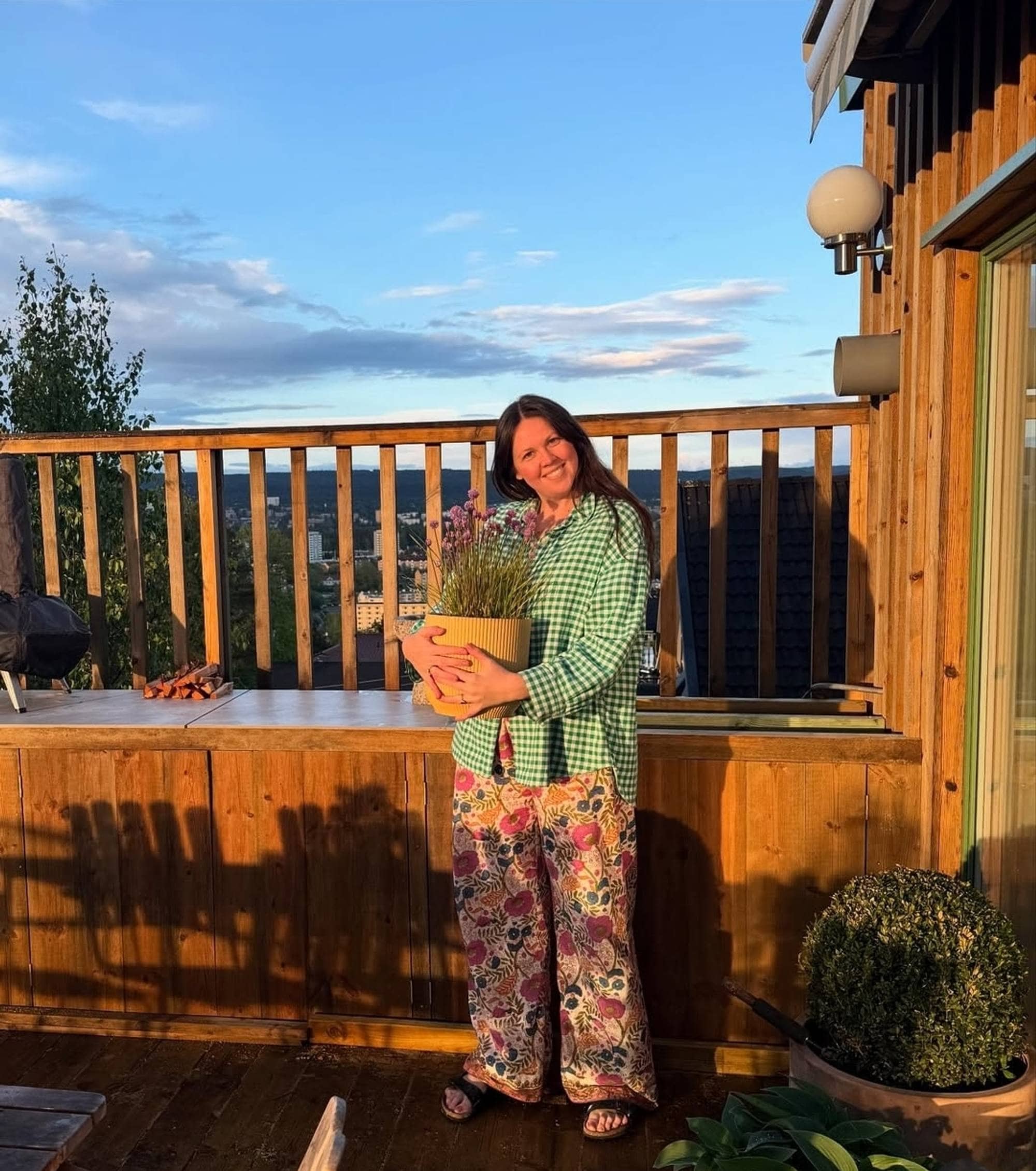 Karoline Kjønniksen med plante på veranda