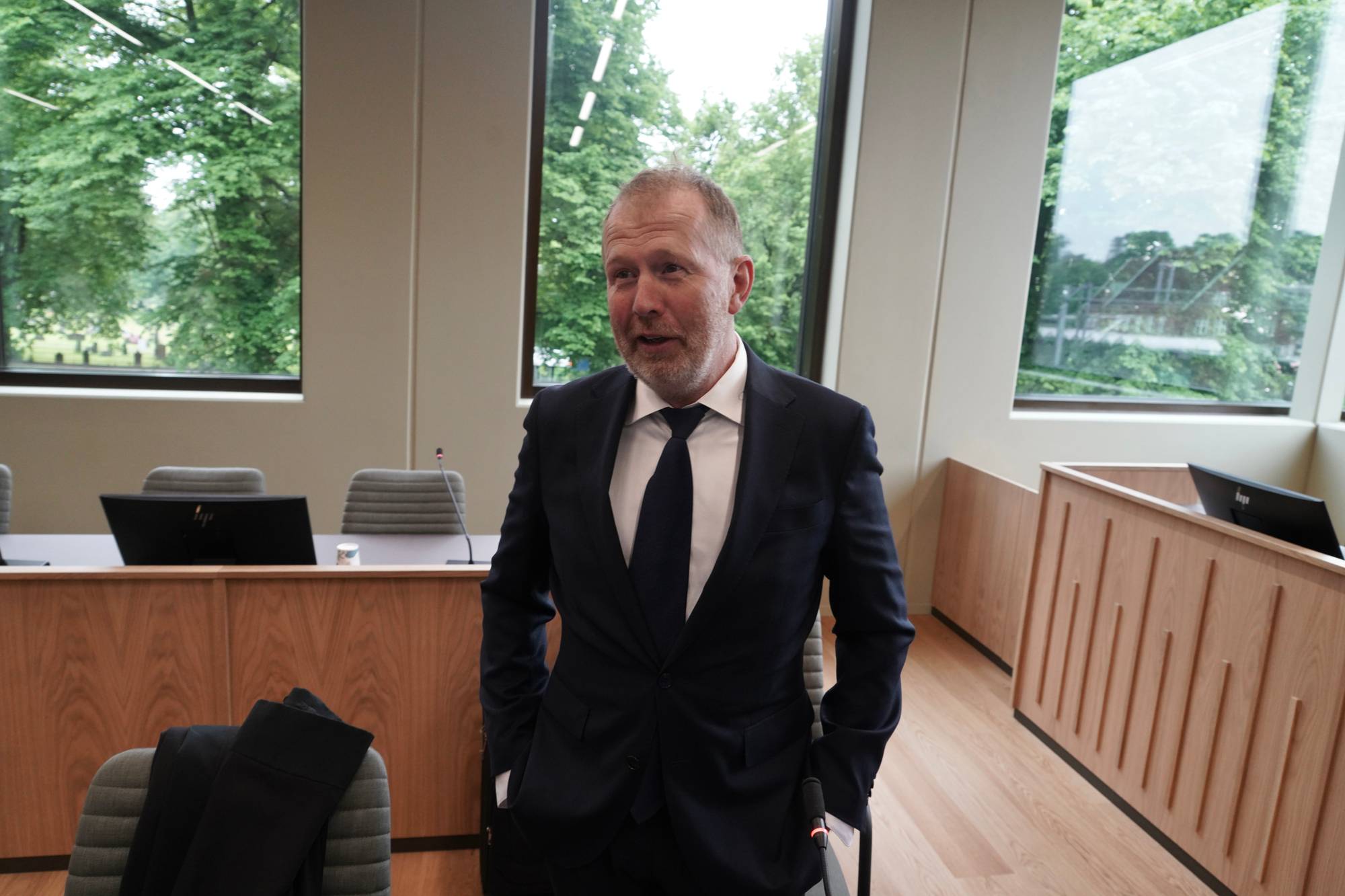 Statsadvokat Peter Johansen i hvit skjorte og dress i en rettssal i Vestfold tingrett med store vinduer. 