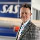 写真:SAS SASモデルの前にいる市松模様のスーツを着た男性