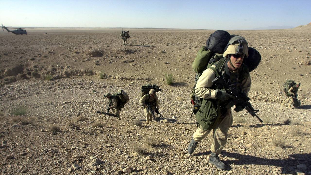 Amerikanske marineinfanterister på jakt etter Al Qaida og deres gjemmesteder. Bildet er tatt etter at de ble sluppet av fra et helikopter utenfor Kandahar i Sør-Afghanistan 10. desember 2001.