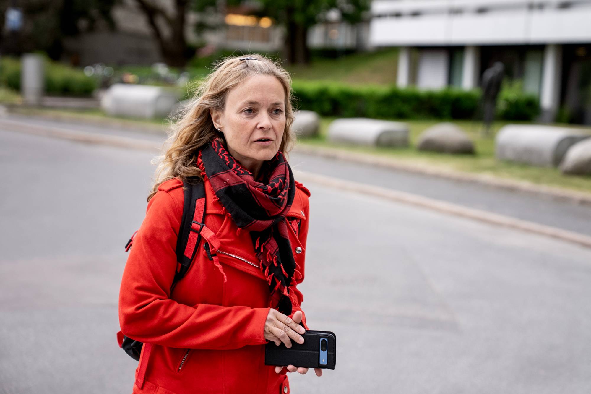 en kvinne som har på seg rød frakk og rulleskøyter
