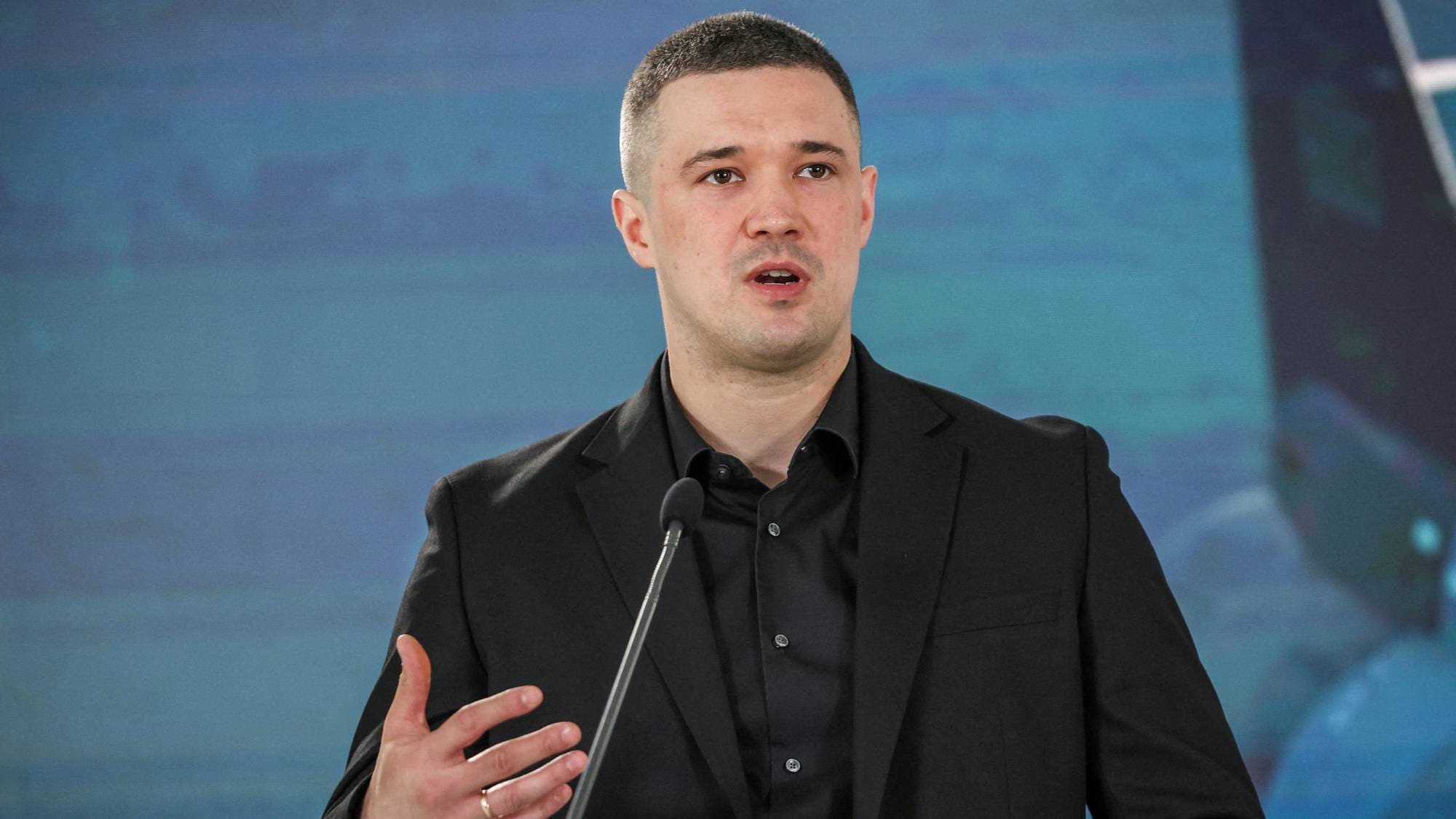 Mykhailo Fedorov, Ukrainas minister for digital transformasjon, snakker foran en mikrofon. (Bildebeskrivelsen er laget av en KI-tjeneste)