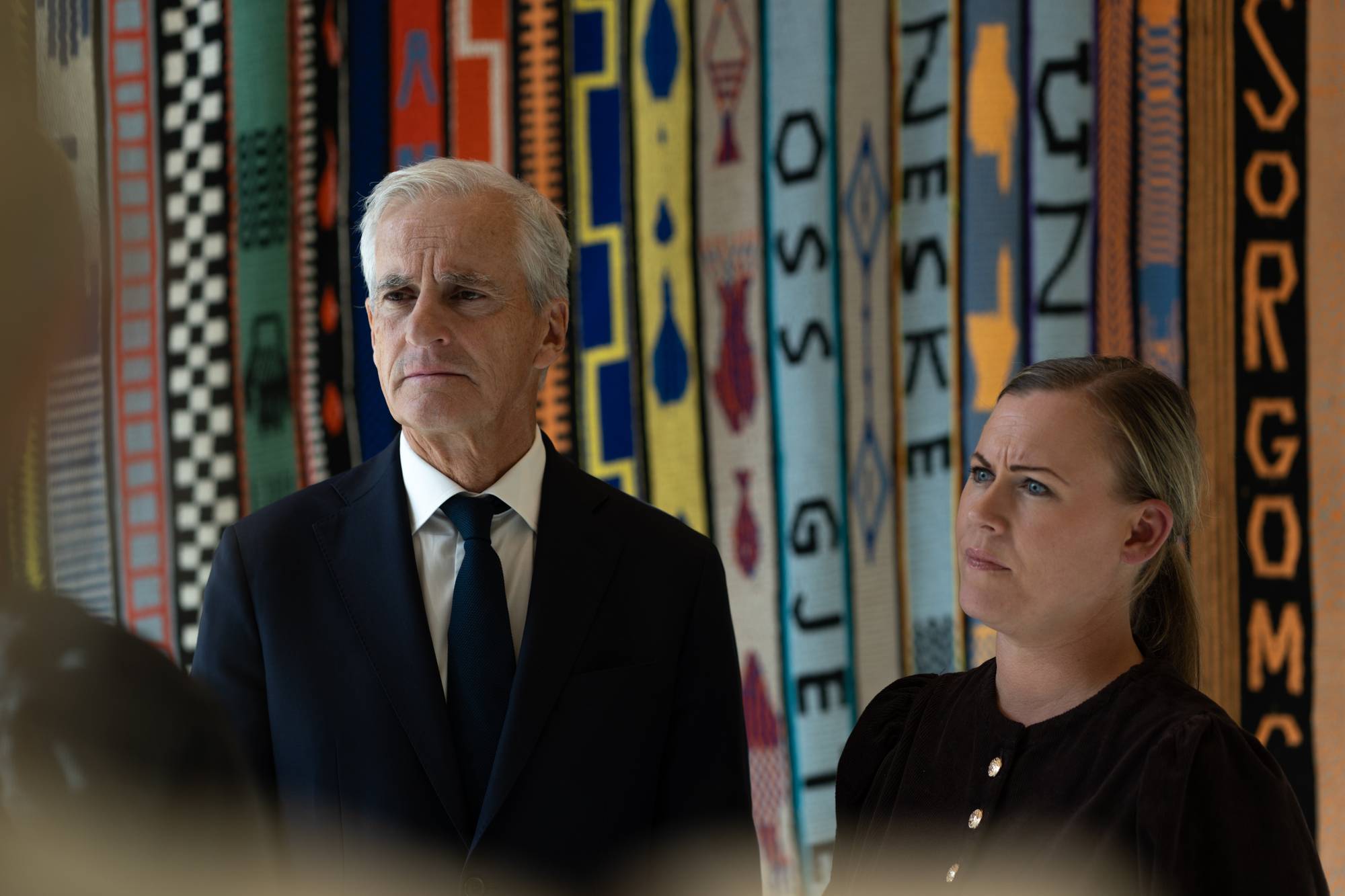 Jonas Gahr Støre og Lene Vågslid snakker til NRK med en fargerik vegg i bakgrunn