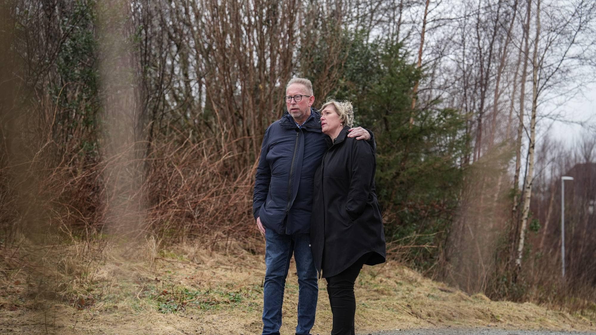 Ektepar går tur rundt et vann. 