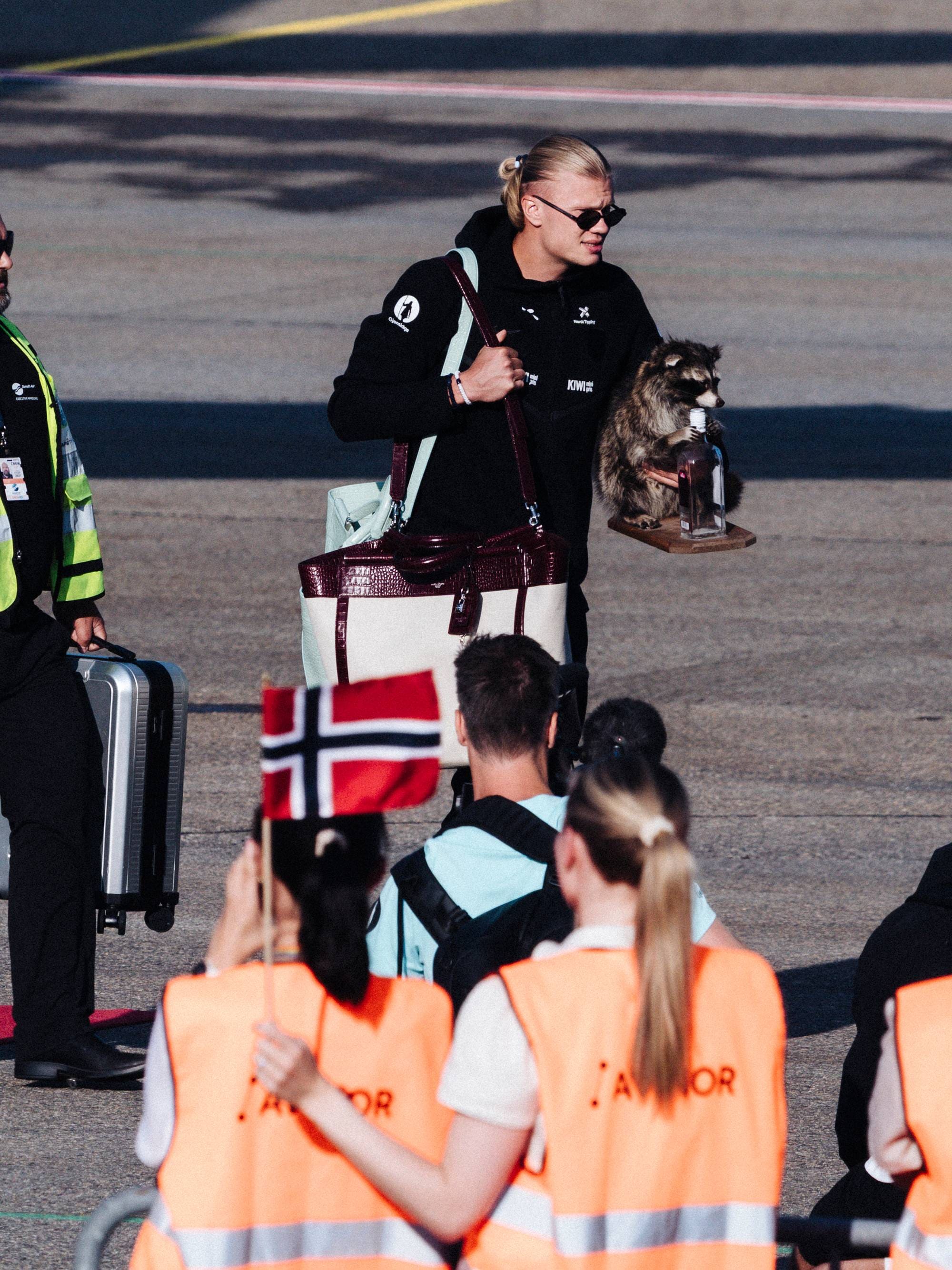 Haaland går inn i en buss på en rullebane på en flyplass.
