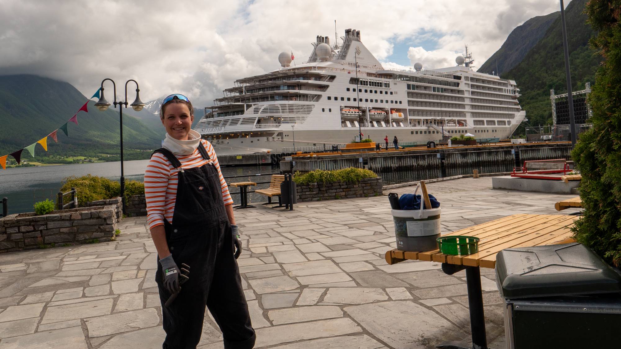 en kvinne og en mann poserer for et bilde foran et cruiseskip (Bildebeskrivelsen er laget av en KI-tjeneste)