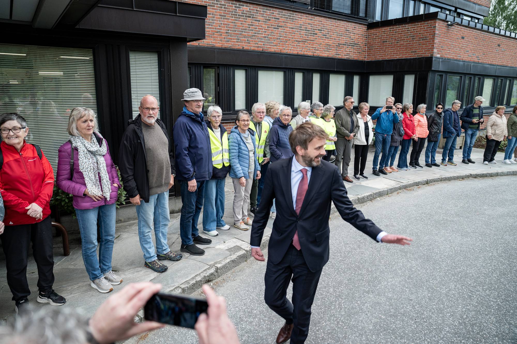 Helseminister Jan Christian Vestre utenfor sykehuset i Volda, der mange hadde møtt opp for å vise motstand mot kuttforslagene i helsesektoren.