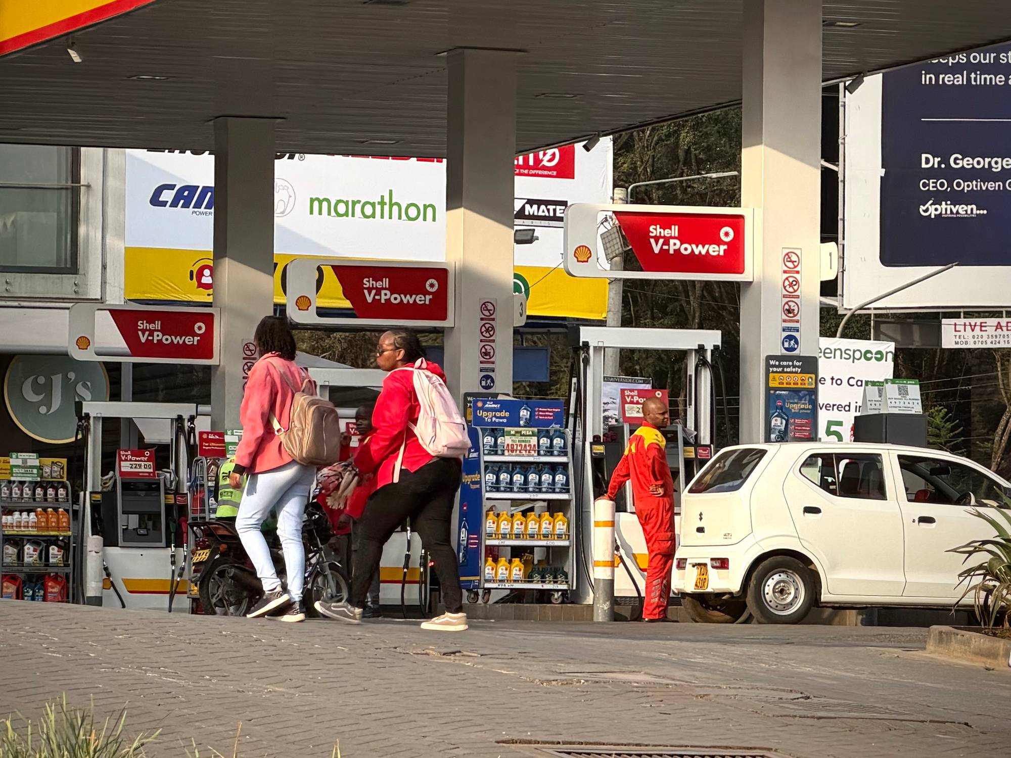 Nokre personar med afrikansk utsjånad går forbi ein bensinstasjon i Nairobi