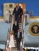 Mark Schiefelbein / AP,NTB Elon Musk ankommer en flyplass med en kvinne i hvit kjole. De går ned en trapp fra et fly med presidentens segl. Flere personer, inkludert uniformerte, står på bakken. (Bildebeskrivelsen er laget av en KI-tjeneste)