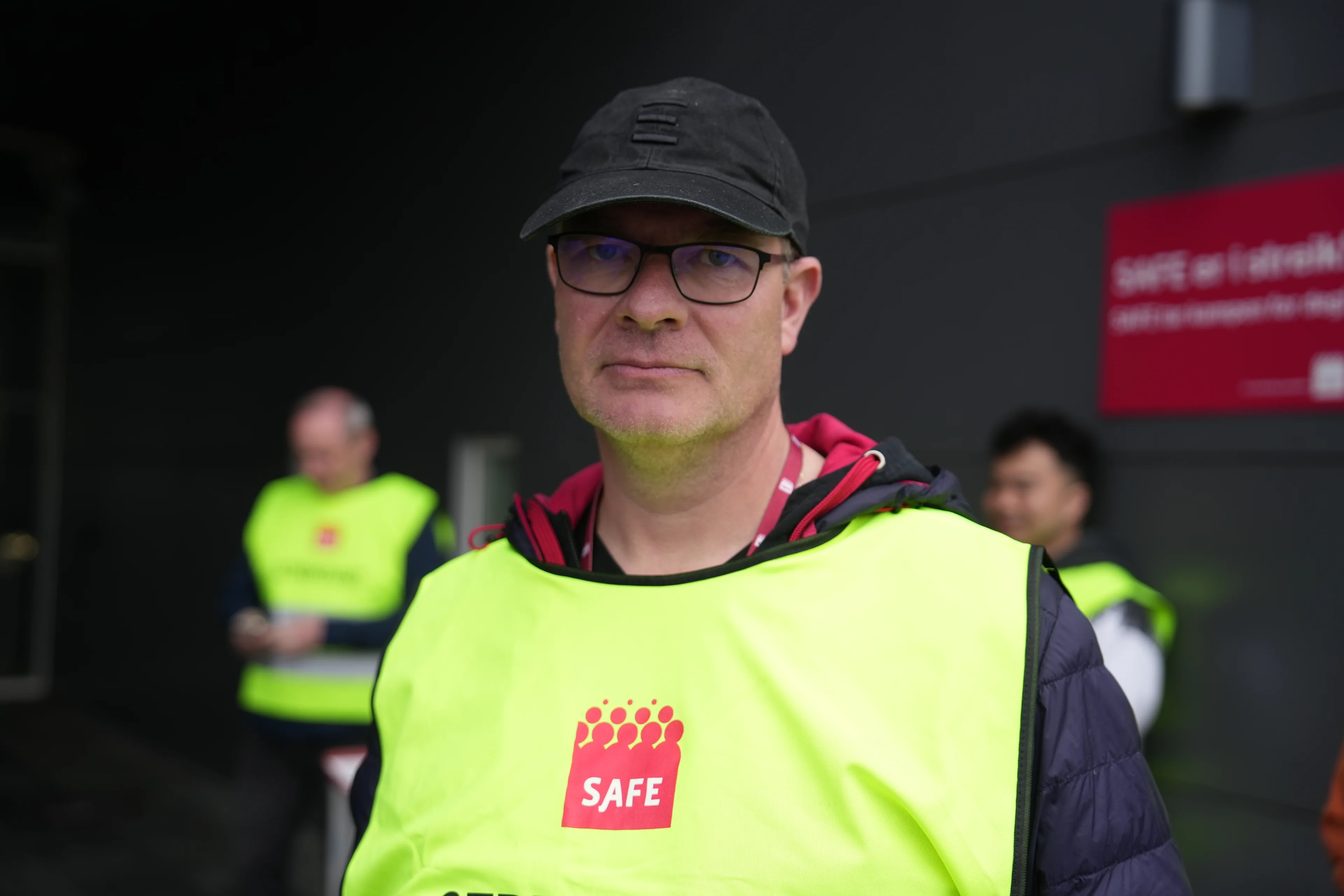 Idar Herland, forbundssekretær i Safe ikledd refleksvest og caps. Han har briller og ser alvorlig ut. I bakgrunnen ser en to andre menn i vest.