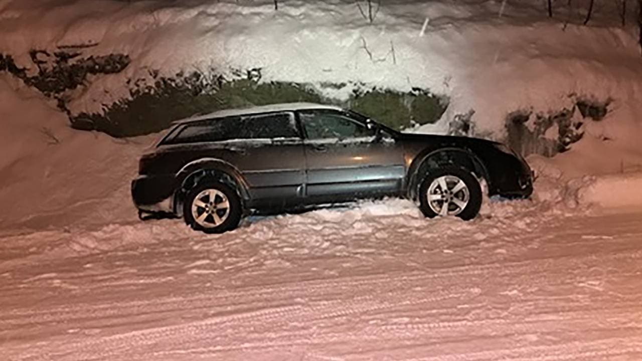 Bil i grøfta sett fra siden ved en snødekt vei