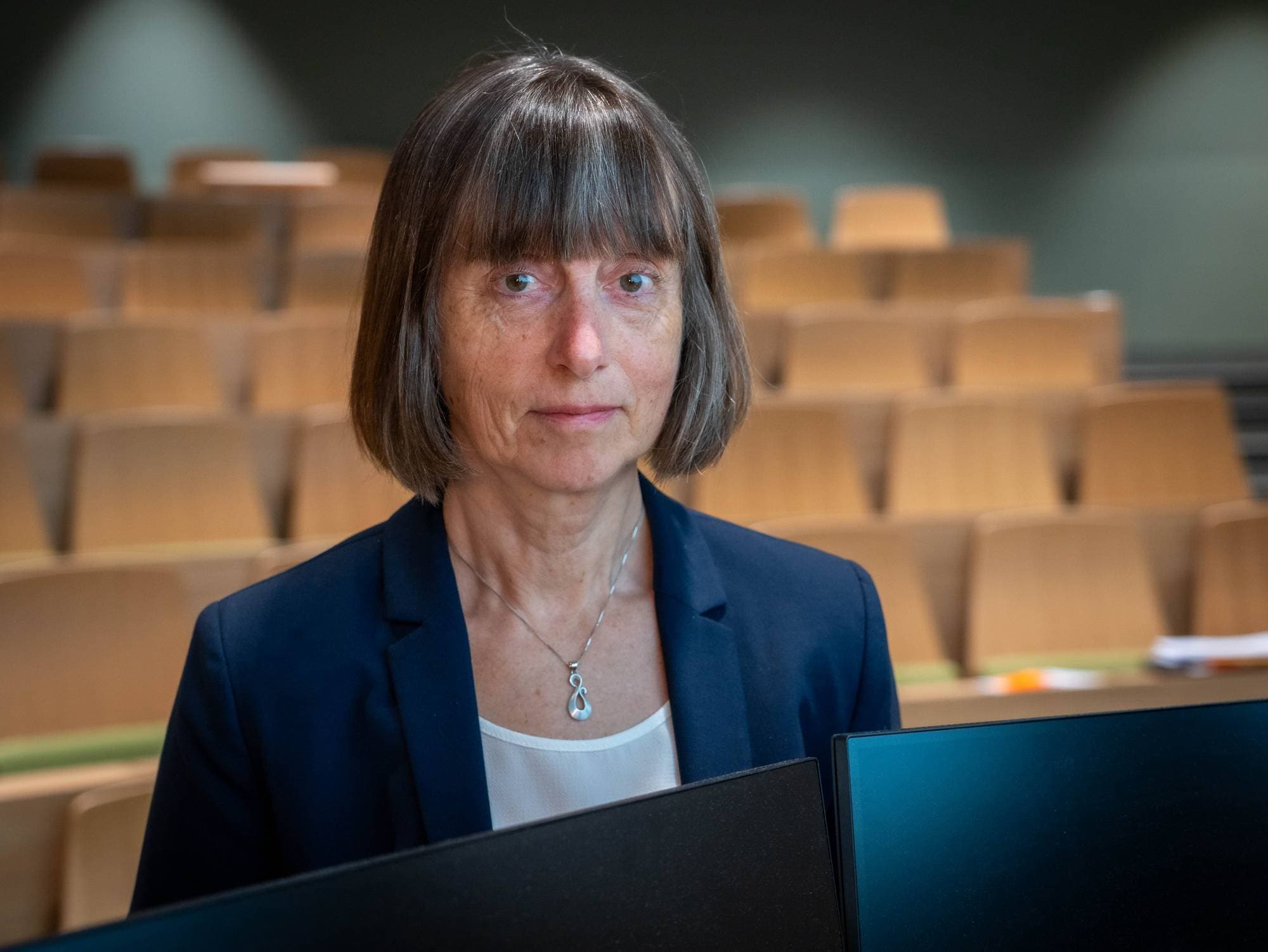 Kvinne med kort hår ser i kamera