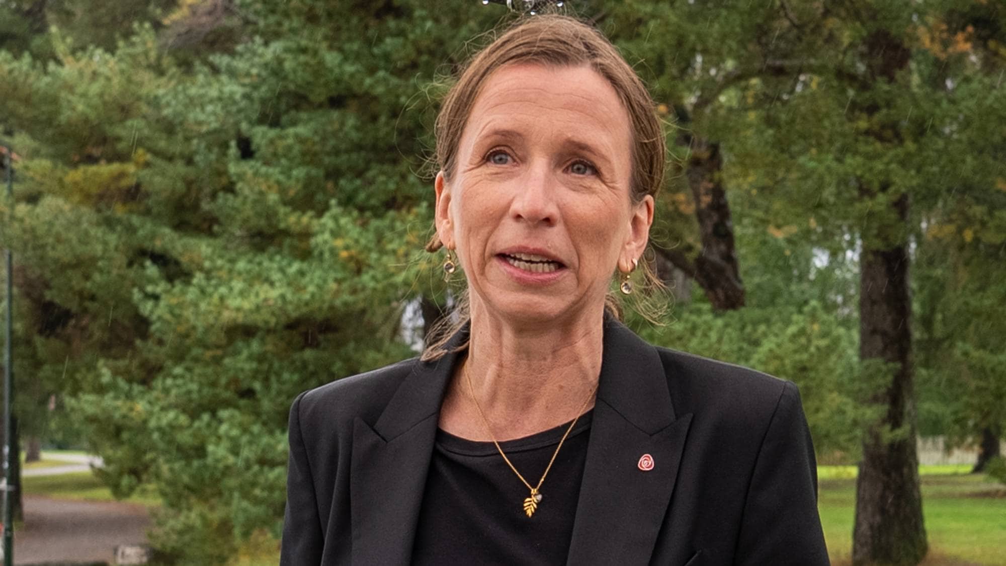 Astrid Aas-Hansen, justisminister, står ved siden av et skilt