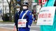 Foto: ISSEI KATO / Reuters Sikkerhetspersonell under Hokkaido-Sapporo Marathon Festival 2021 med plakater med teksten "For å unngå smitte, vær snill å la være å se på"