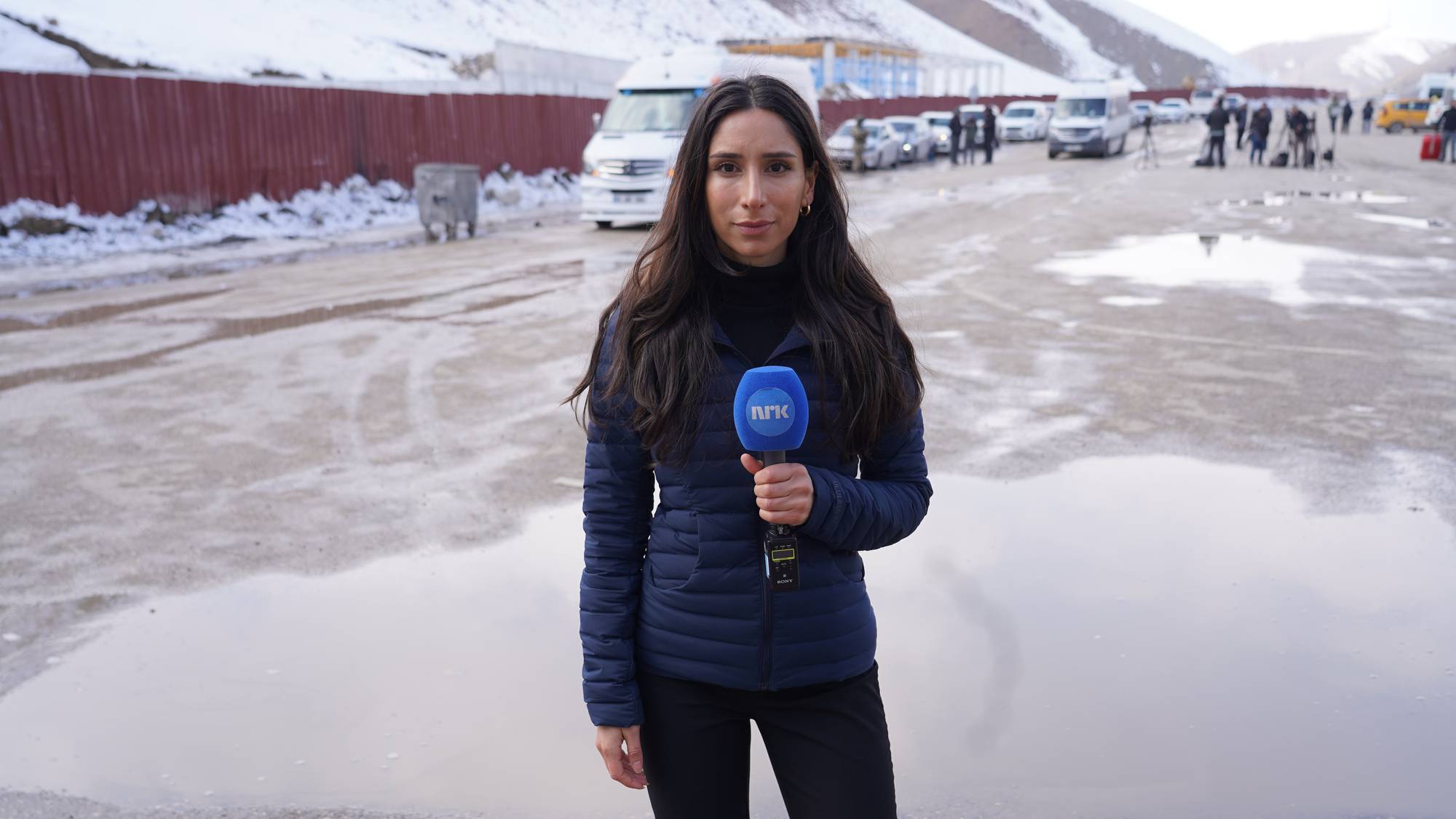 En kvinne står på grensen mellom Iran og Tyrkia. 