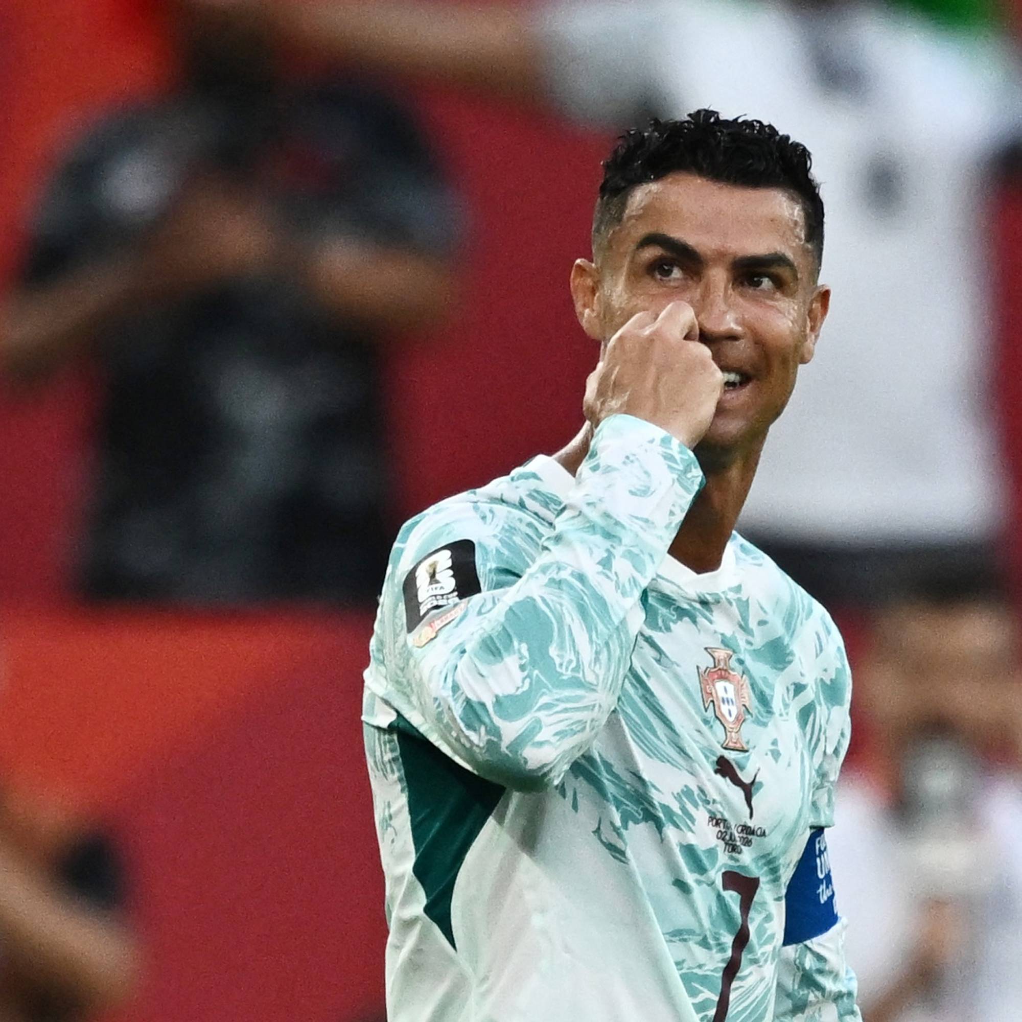 Cristiano Ronaldo i Portugals landslagsdrakt feirer på fotballbanen. (Bildebeskrivelsen er laget av en KI-tjeneste)