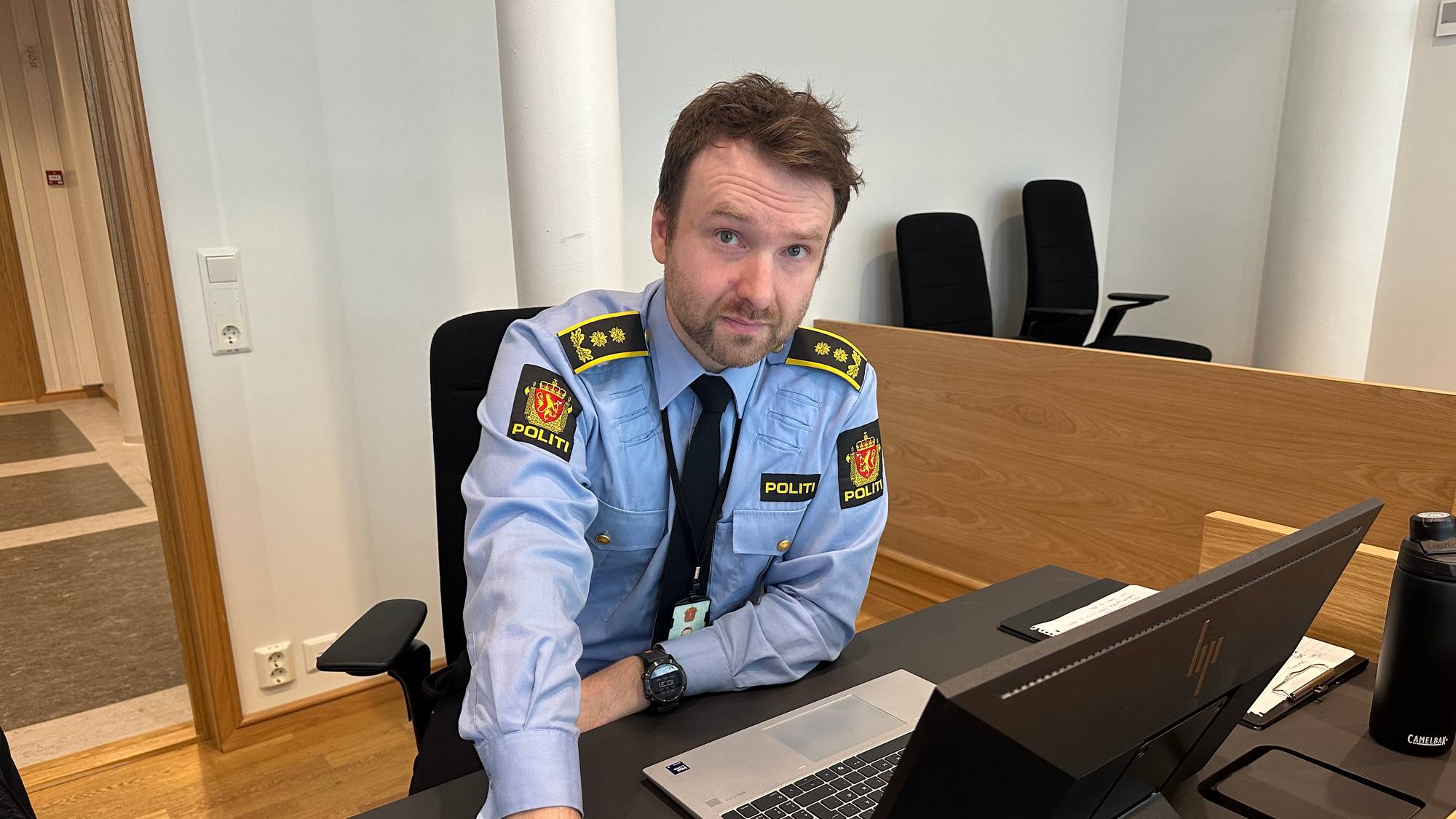 en politimann som sitter ved et skrivebord