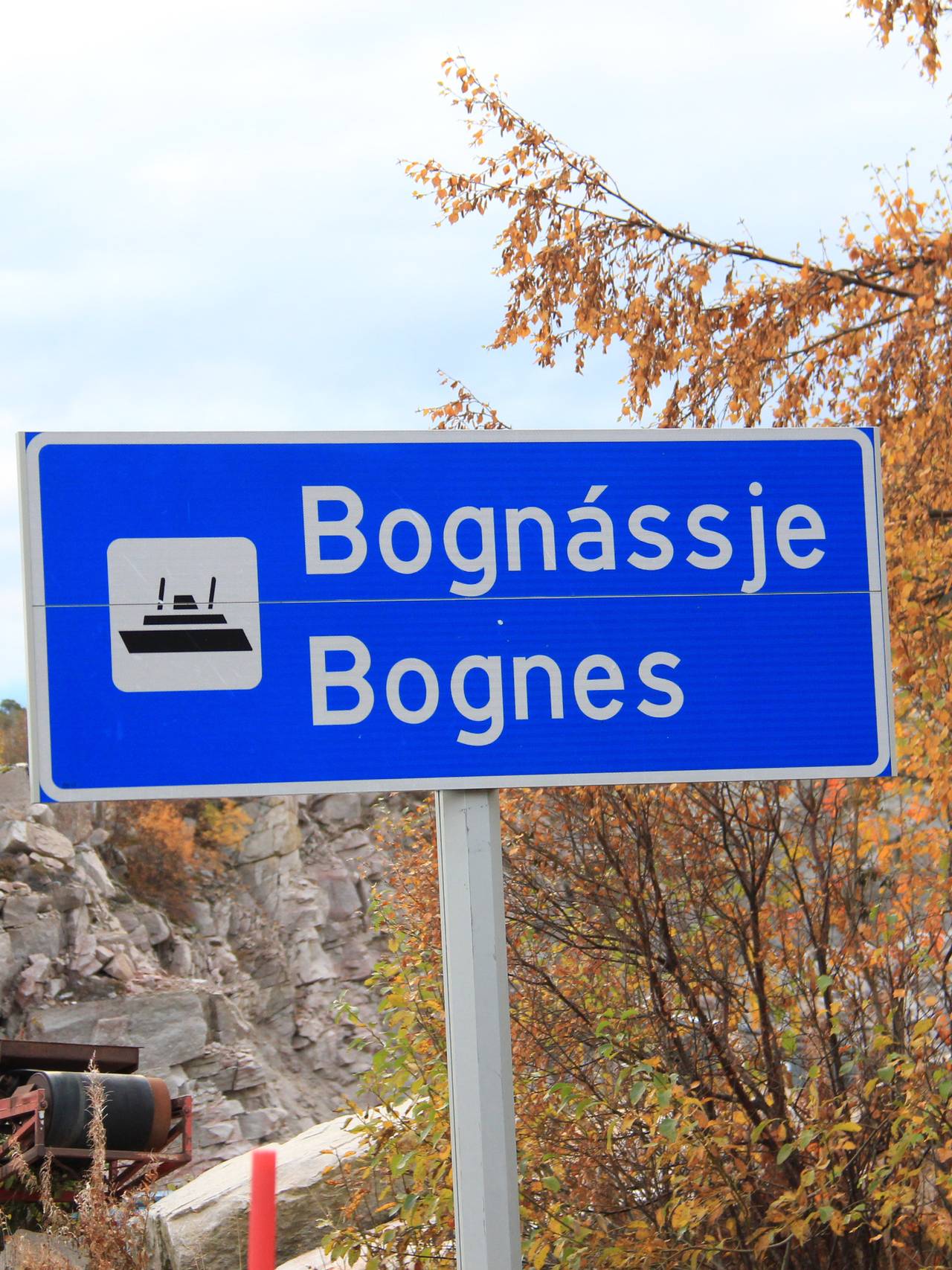 Blått vegskilt for fergeleie Bognássje/Bognes med fergesymbol på.