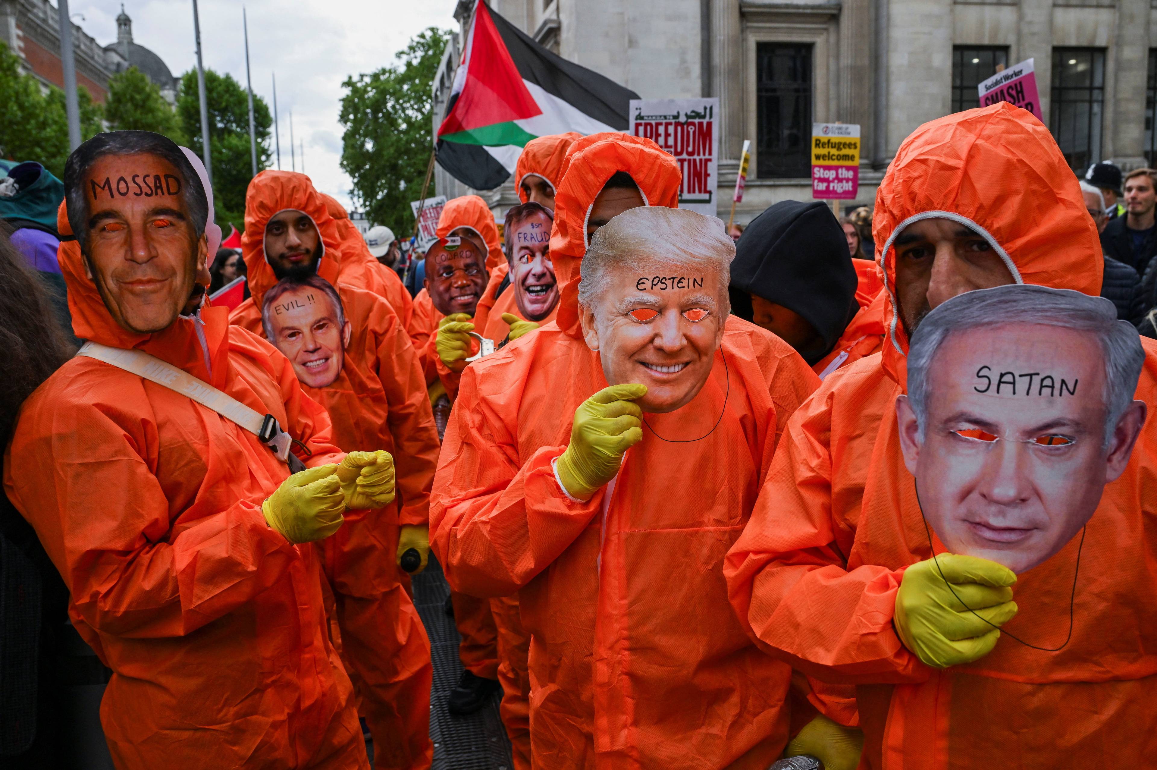 Folk i oransje kjeledresser holder pappmasker med ansiktene til Donald Trump, Benjamin Netanyahu, Jefferey Epstein i det po-palestinske protesttoget i London.