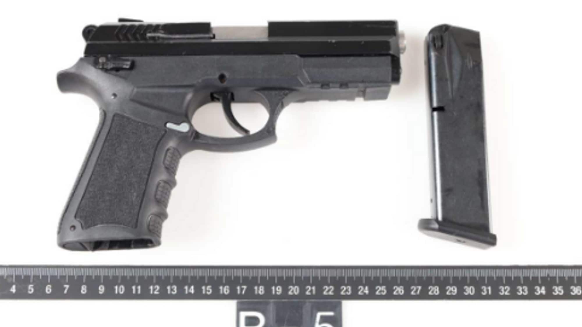 viser en svart pistol i politiets beslag