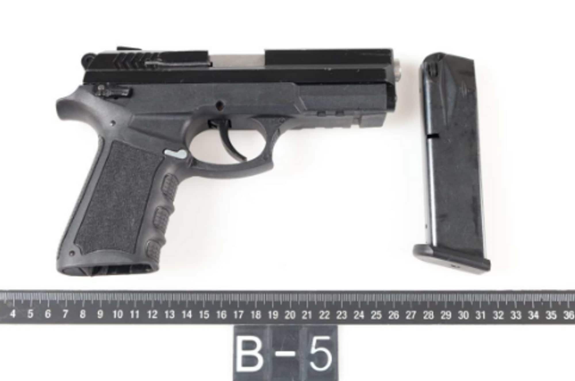 viser en svart pistol i politiets beslag