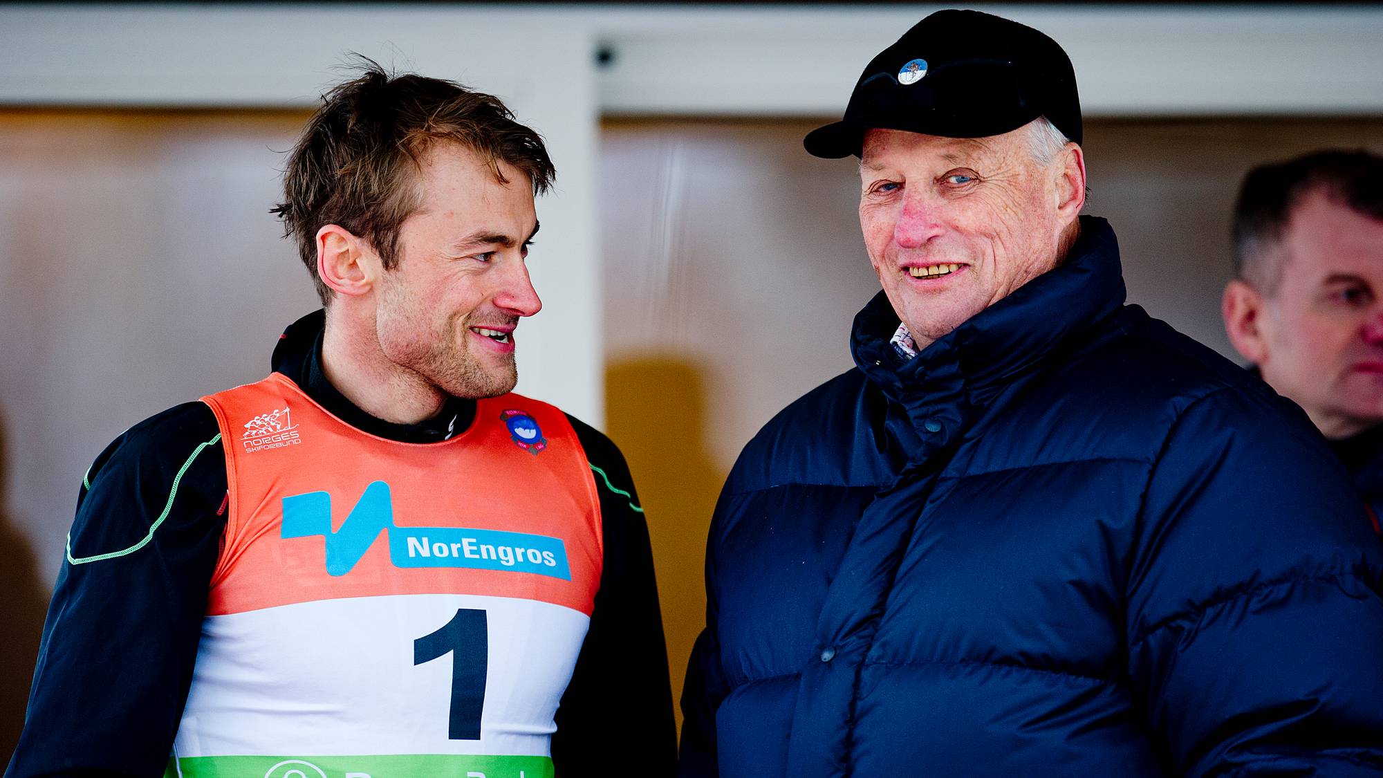 Petter Northug smiler til kong Harald under en skirennkonkurranse. (Bildebeskrivelsen er laget av en KI-tjeneste)