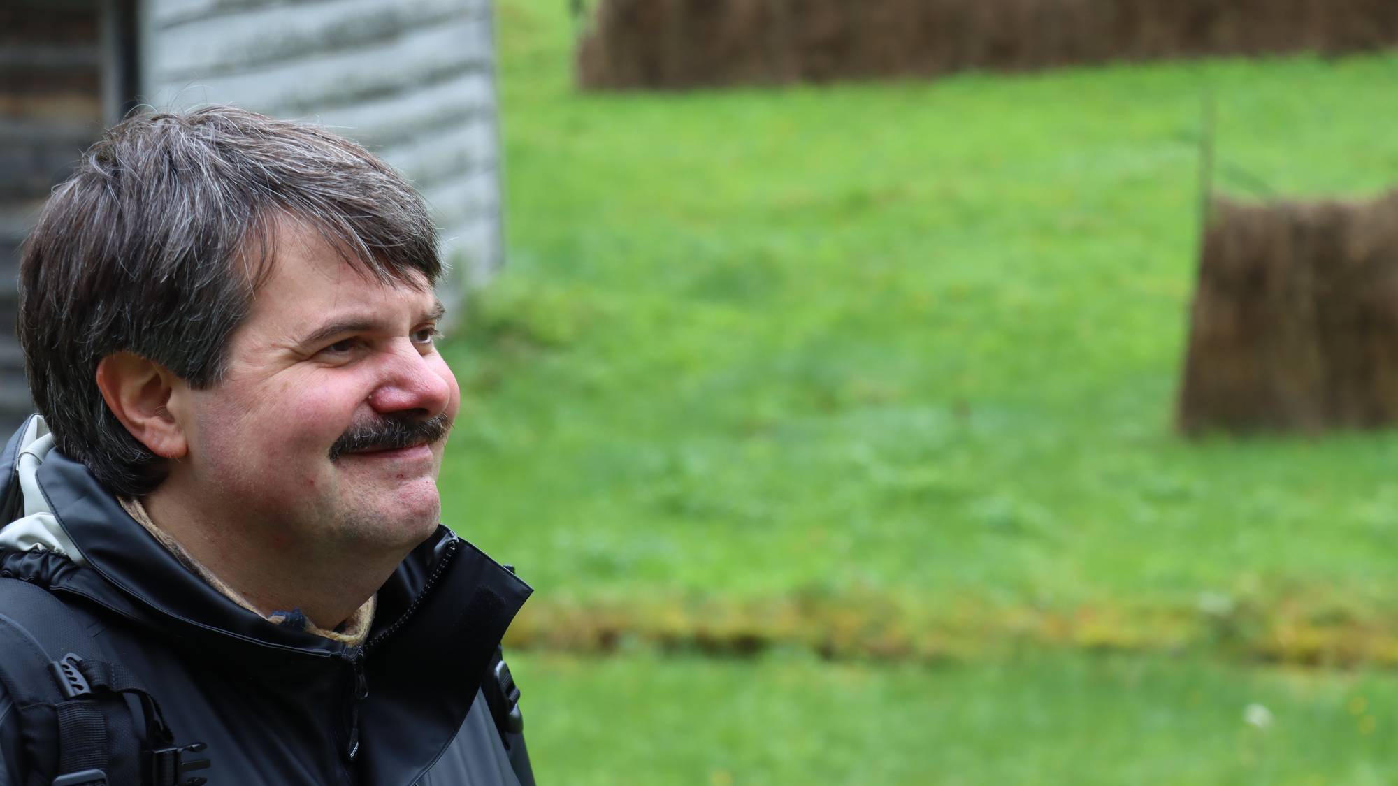 Mann som smilar, bak han er det grønt gras.
