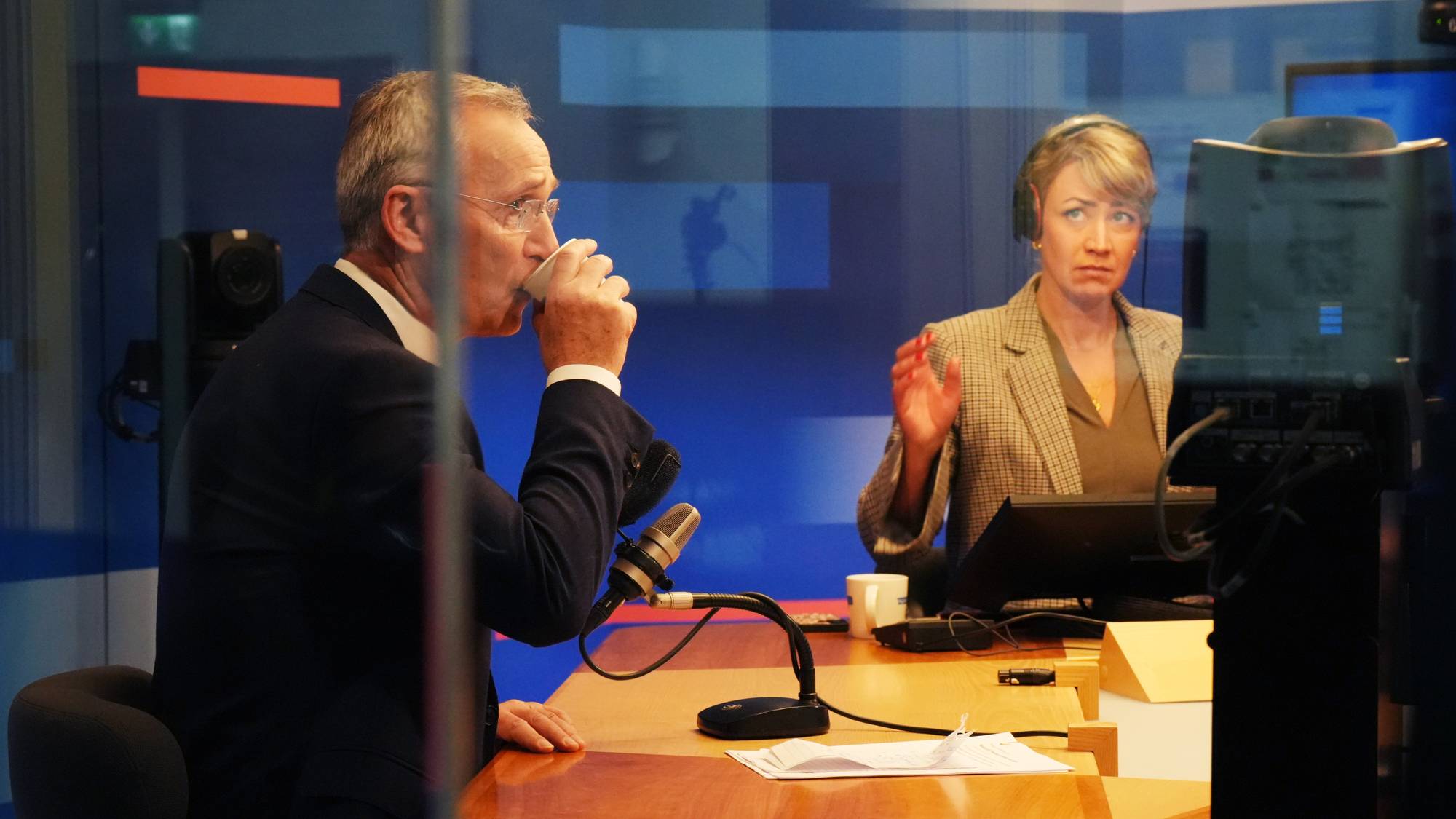 Jens Stoltenberg drikker av pappkopp i NRKs radiostudio