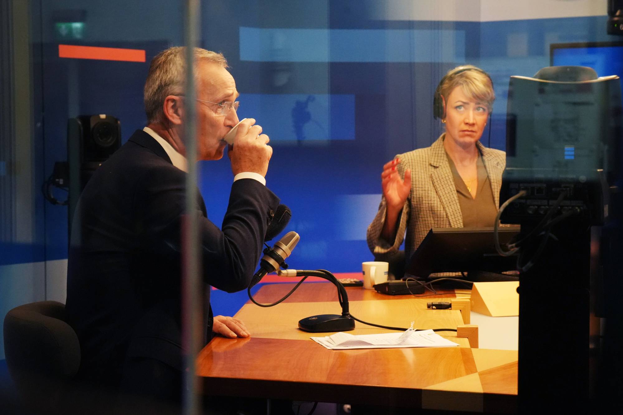 Jens Stoltenberg drikker av pappkopp i NRKs radiostudio