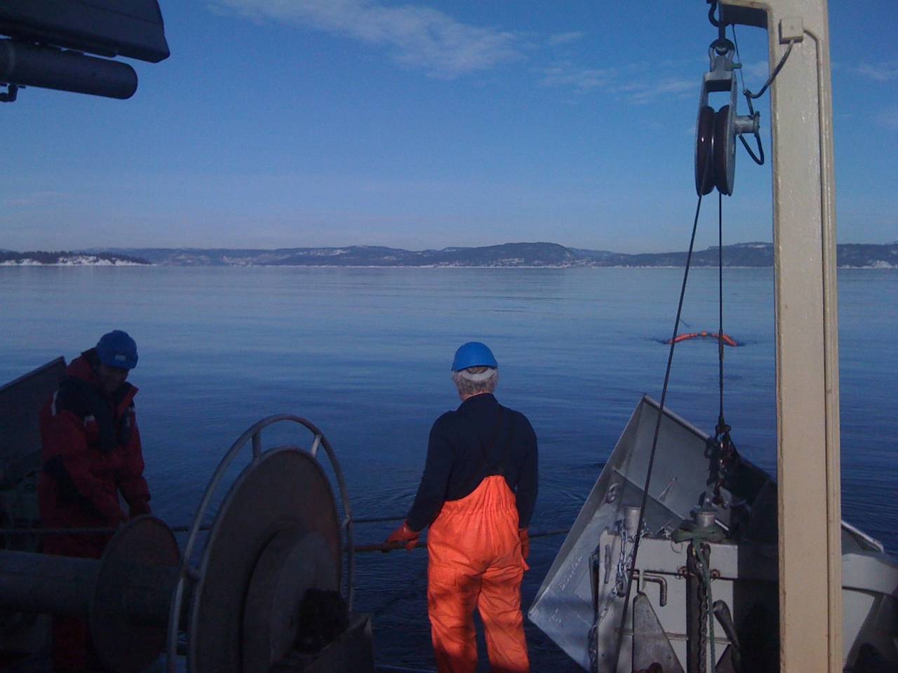 Bildet er tatt om bord på en fisketråler. Vi ser en person ser ut over fjorden.
