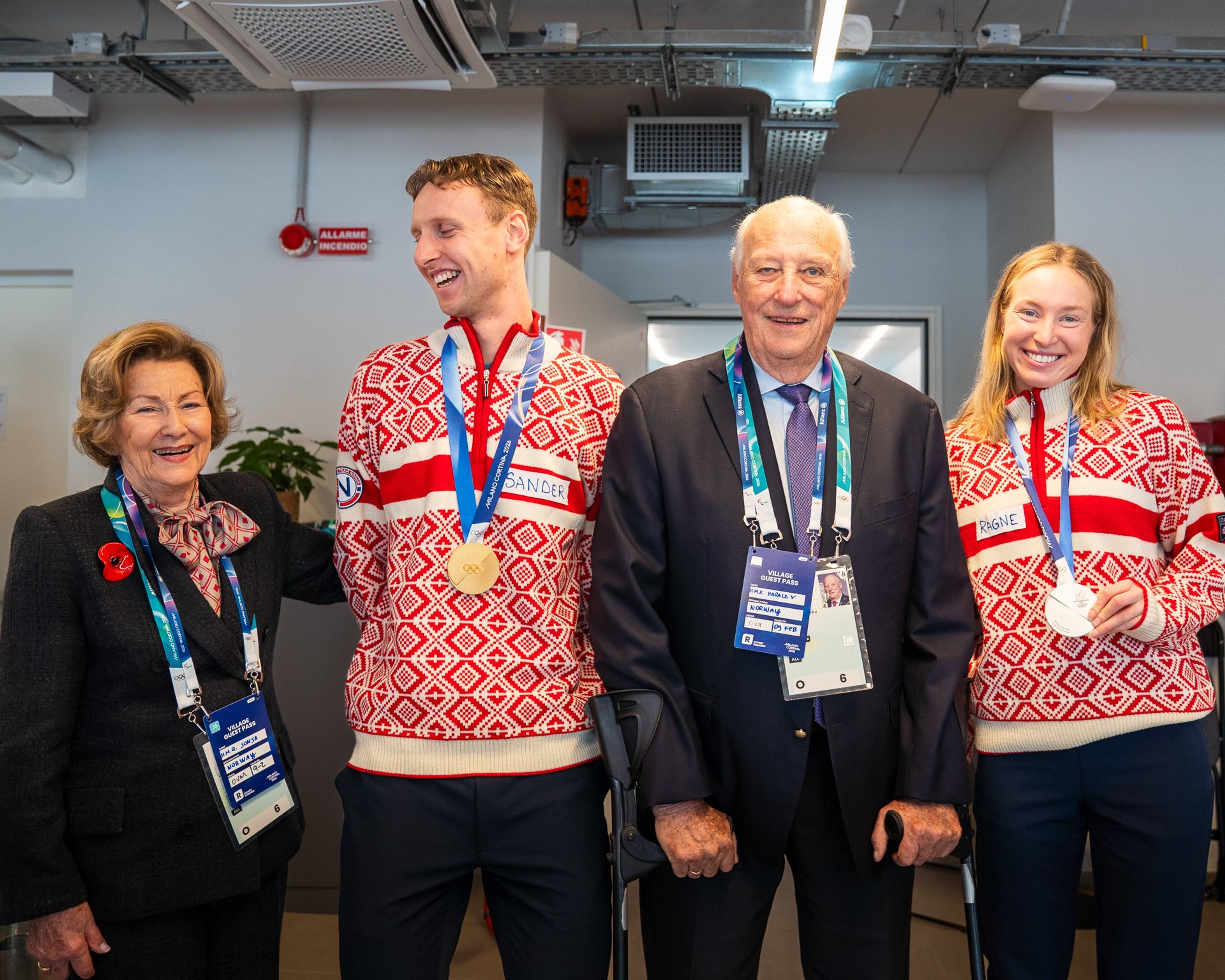 Kong Harald og dronning Sonja sammen med skøyteløperne Sander Eitrem og Ragne Wiklund, som står med sine OL-medaljer rundt halsen.