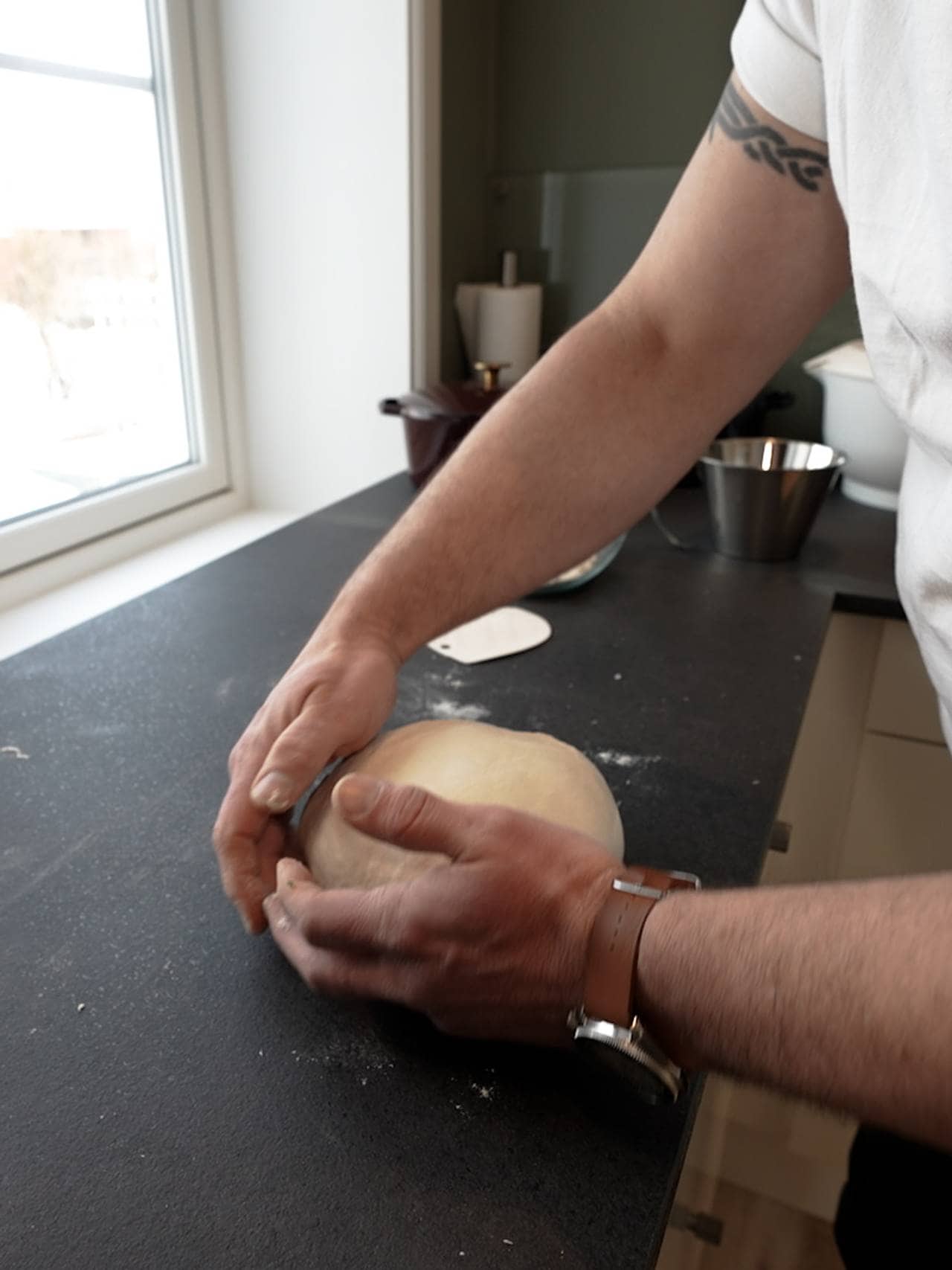 Reuben Quinnell Cleaver ruller brøddeigen på kjøkkenbenken. 