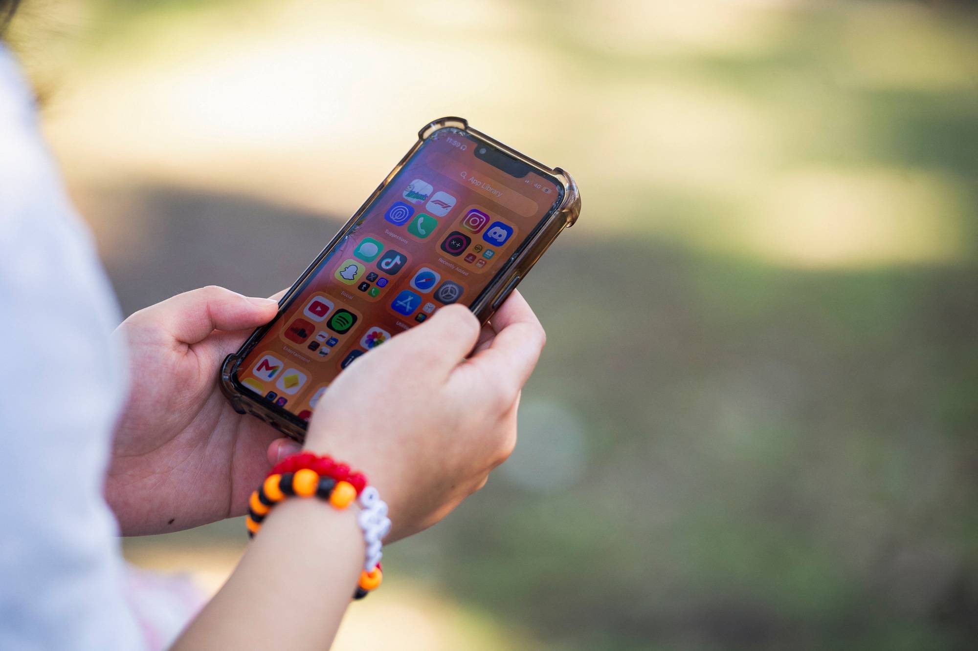 Viser en person som holder en telefon. Noen apper på telefonen er synlig. 