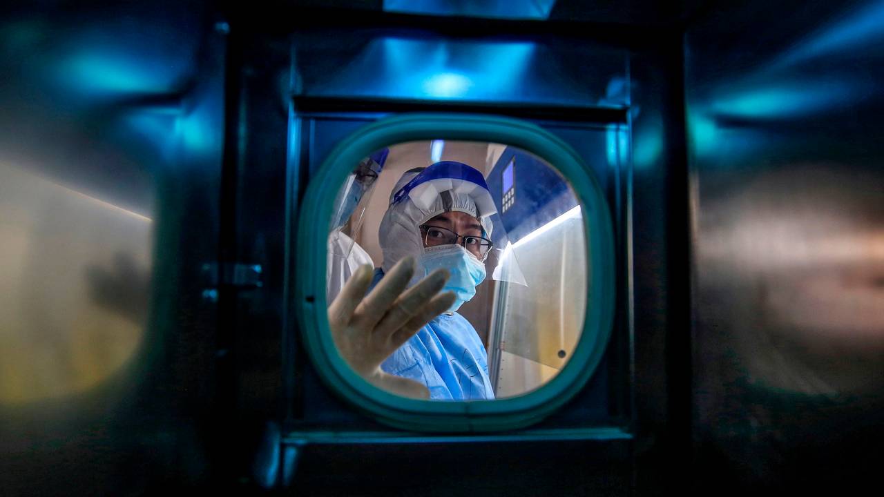 A hospital employee greets from an isolation room at the Red Cross Hospital in Wuhan on March 10. 