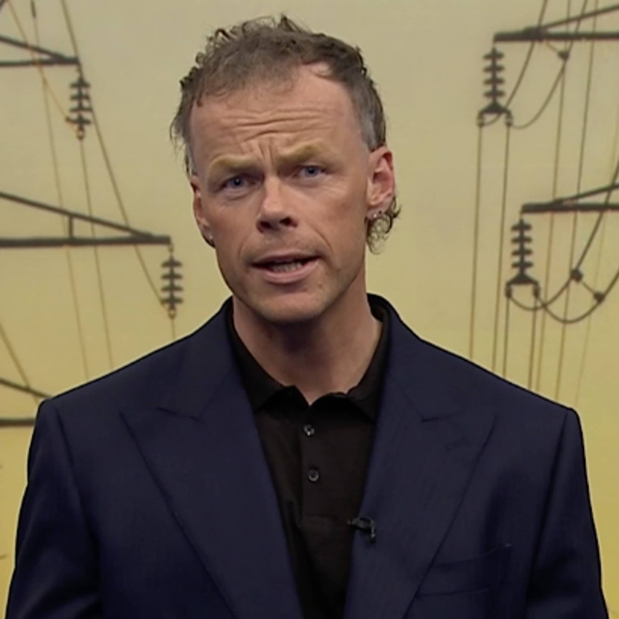 Mann foran bilde av strømledninger.