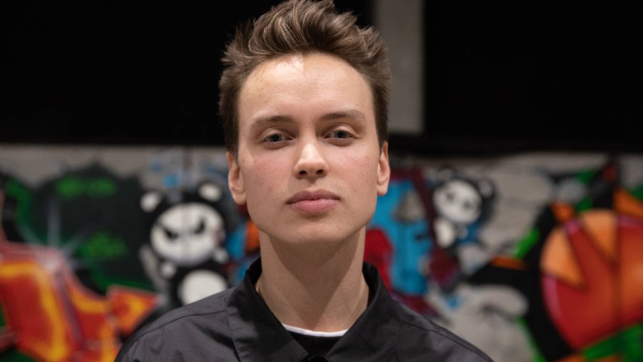 Benjamin Andrésen med åpne øyne foran en vegg med en stor grafitti-piece