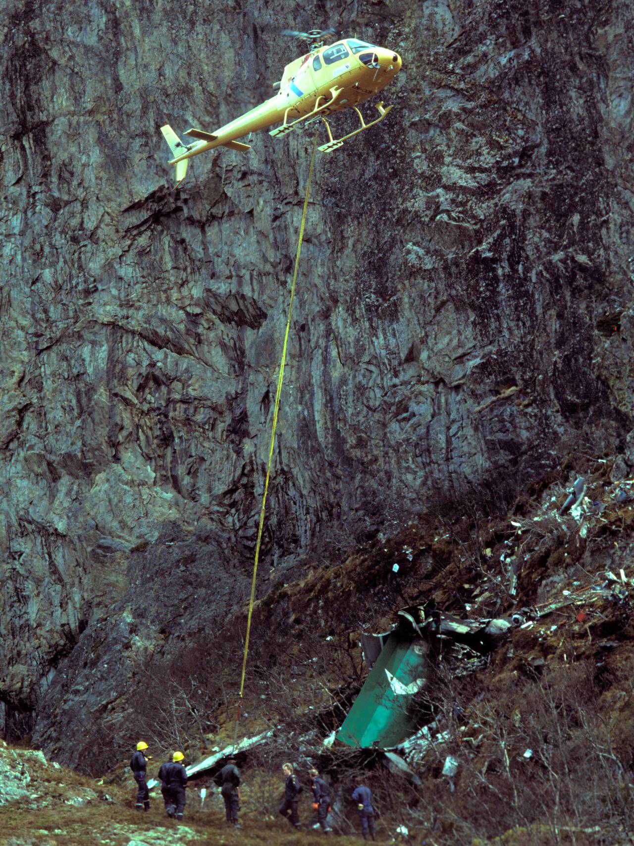 Flyulykke ved Torghatten. En Dash-7 fra Widerøe styrtet i fjellsiden 6. mai 1988. Redningsmannskaper arbeider på ulykkesstedet blant vrakrester . Helikopter blir brukt