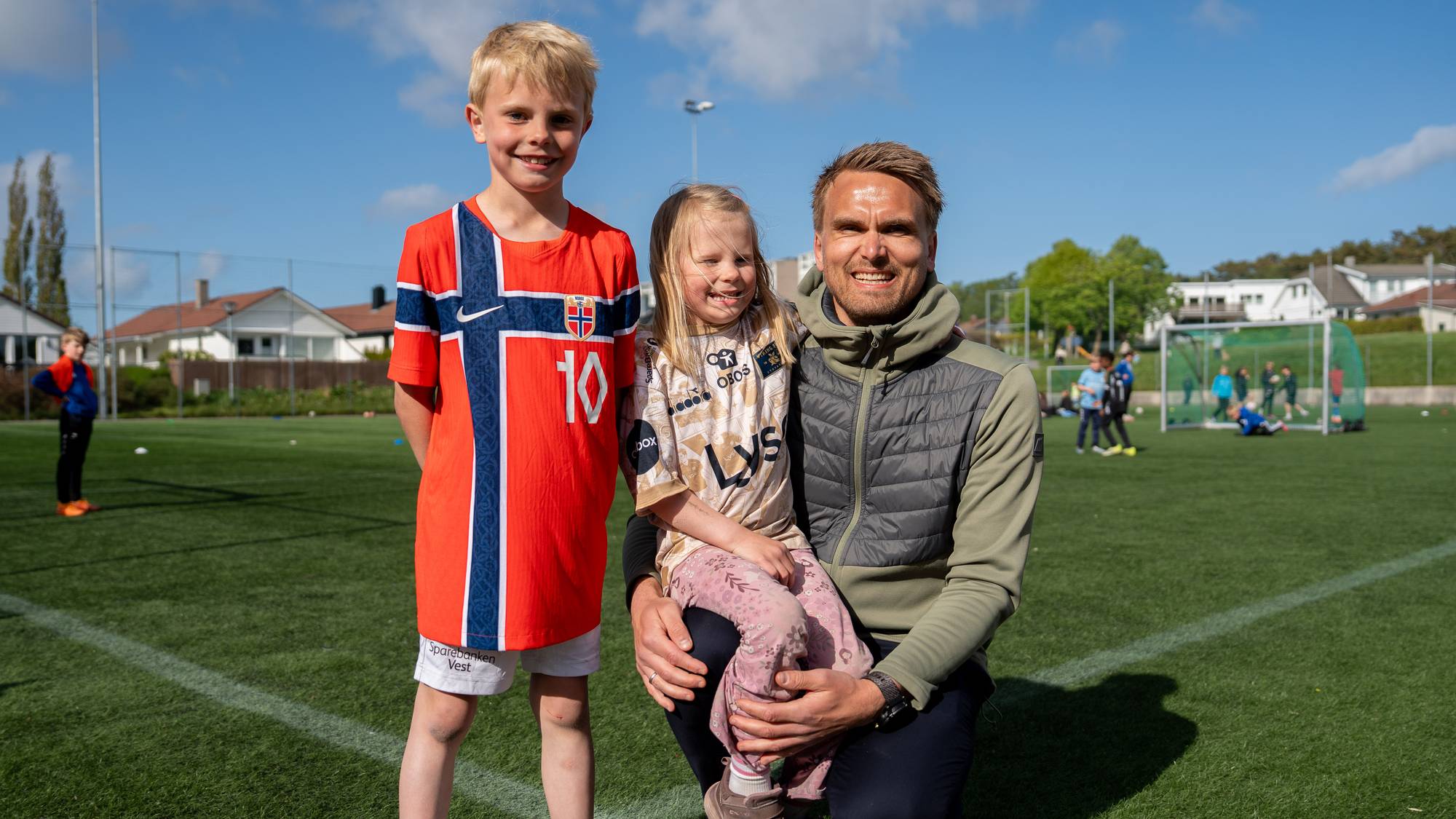 Familie på fotballbane. 