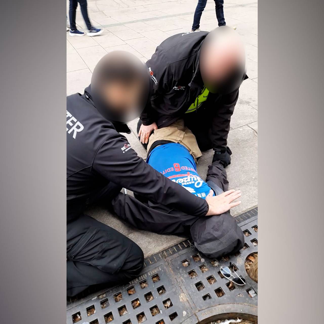 To vektere holder en mann nede i gågata i Fredrikstad
