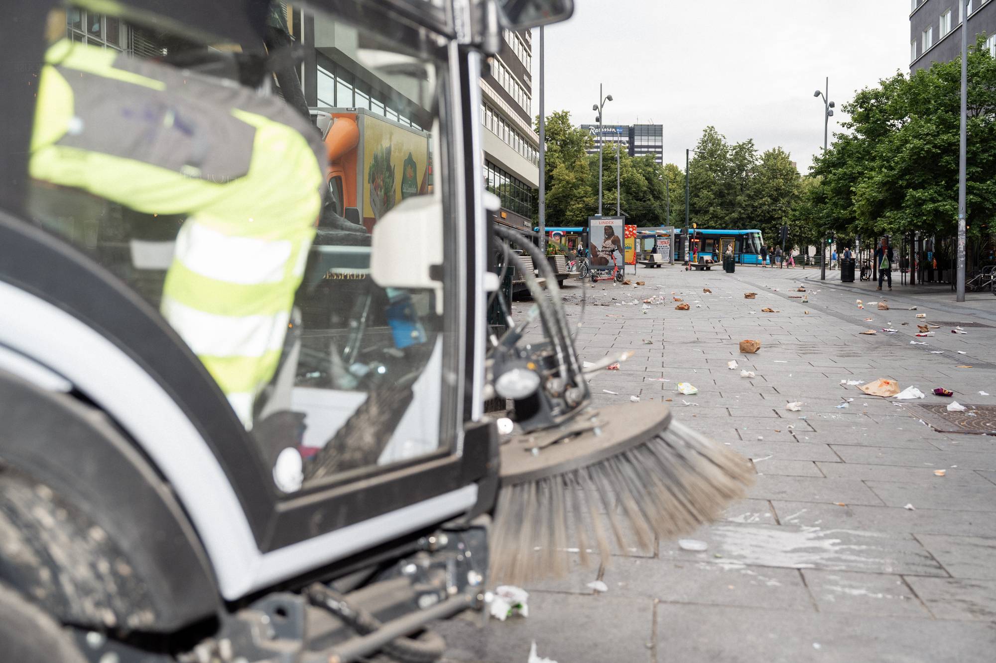 Feiemaskin rydder forsøpling på et bytorg i Oslo. (Bildebeskrivelsen er laget av en KI-tjeneste)