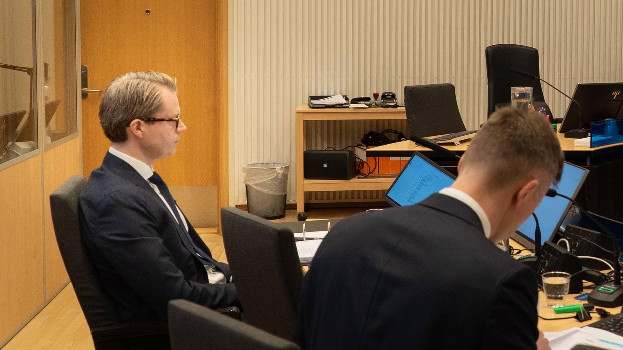 To advokater sitter i en rettssal og gjør klar pc og papir.