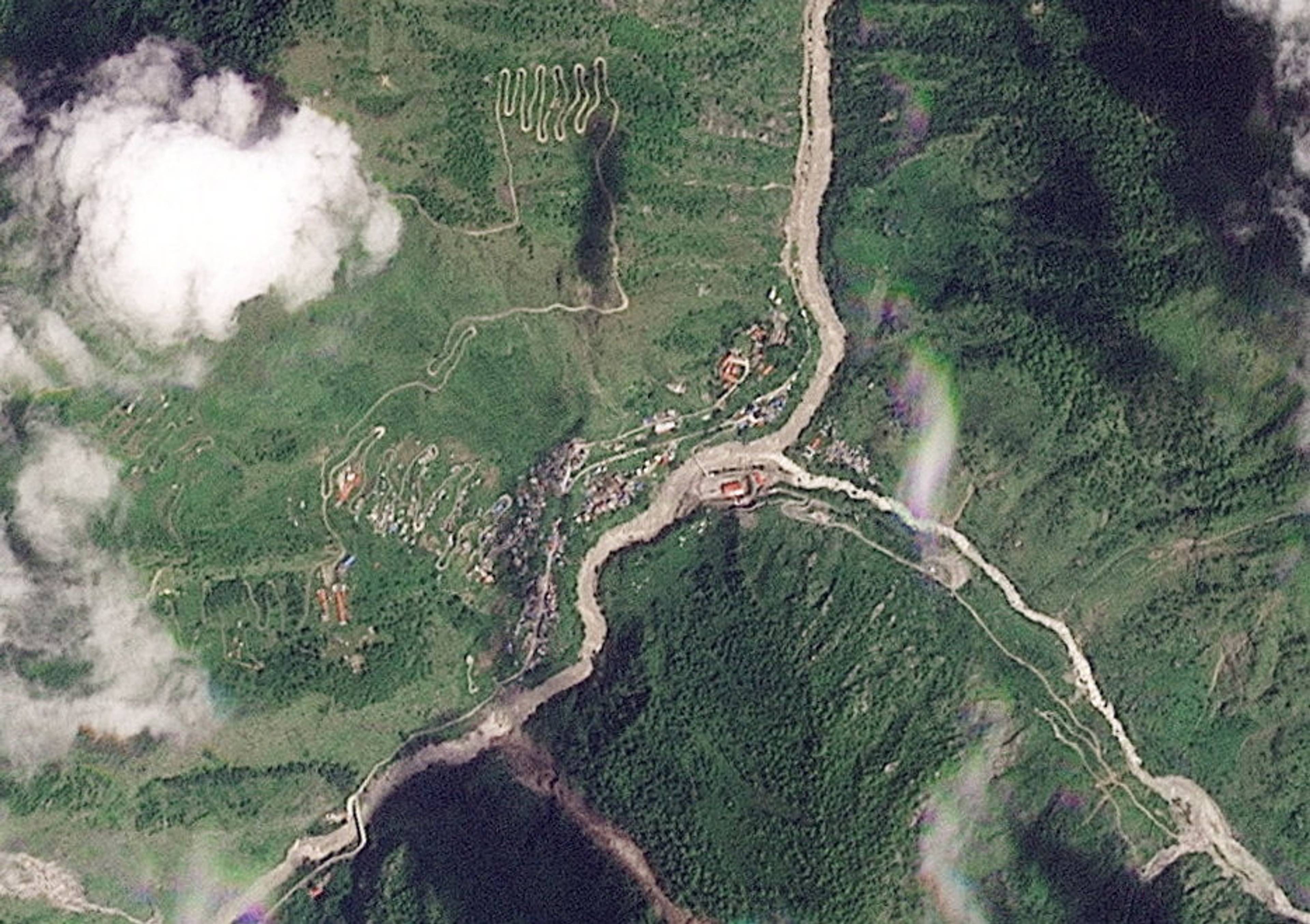 Satellittbilde av et fjellområde med svingete veier, tett vegetasjon og en elv. (Bildebeskrivelsen er laget av en KI-tjeneste)