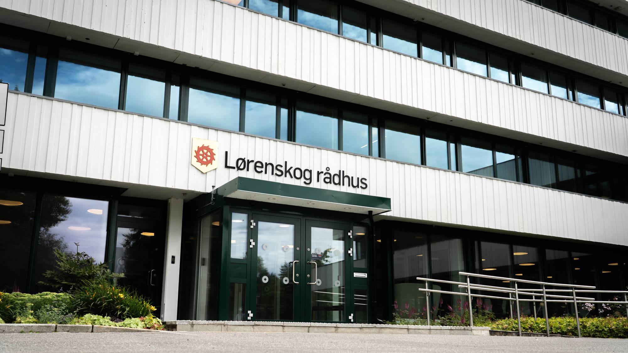Inngangspartiet til Lørenskog rådhus med skilting og grå fasade. 
