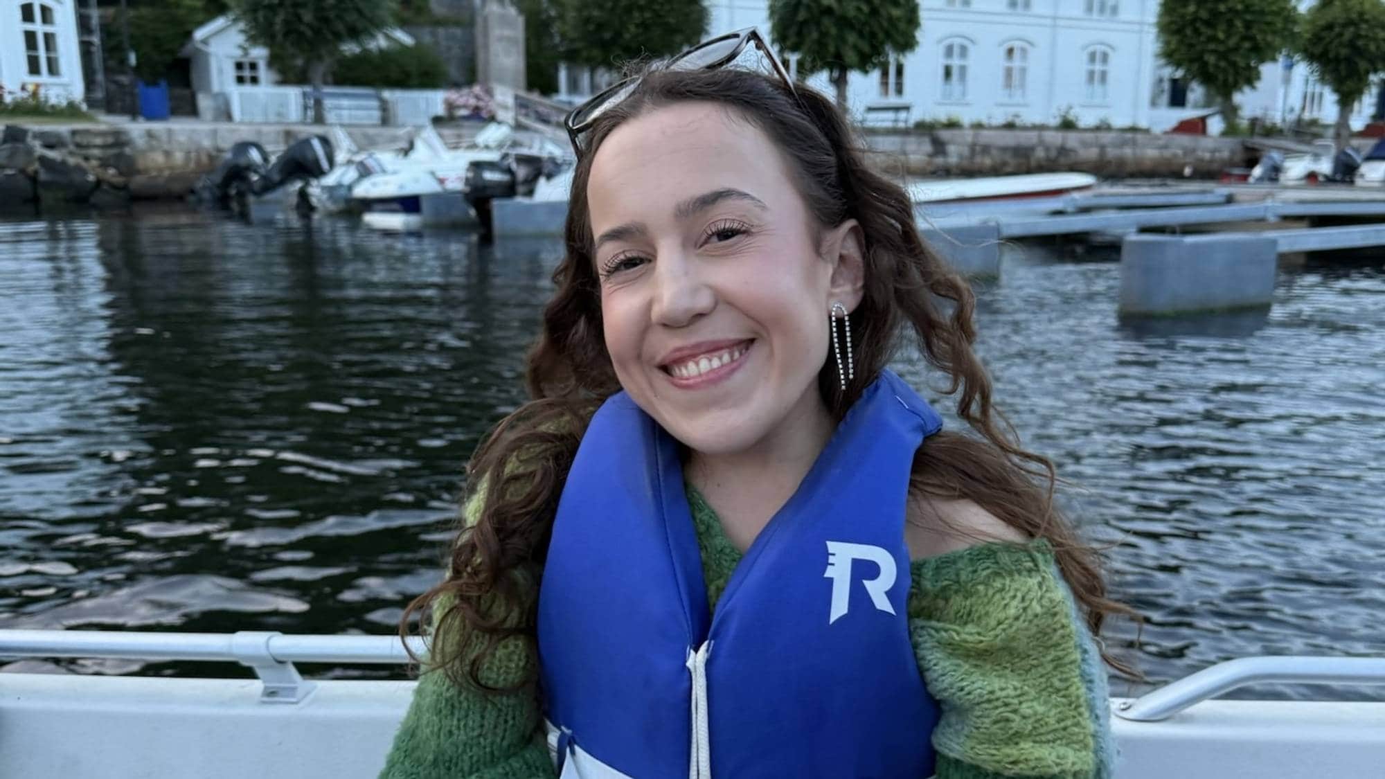 Ei dame med redningsvest i ein båt 