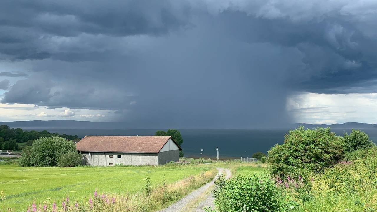 Mørke skyer og regn over Trondheimsfjorden. Bildet er tatt fra Frosta.